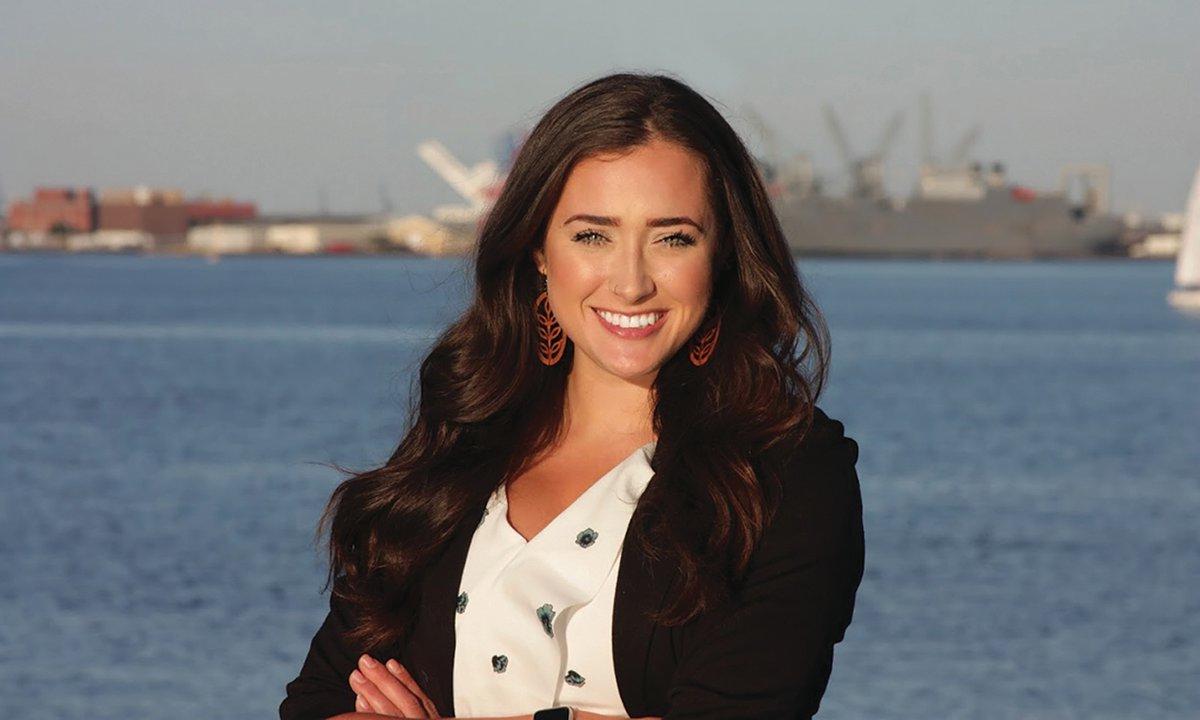 Smiling woman with water in background.